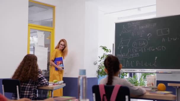 Professora entra na sala de aula e começa a lição na escola moderna — Vídeo de Stock