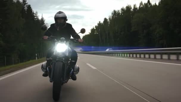 Homem andando de moto scrambler na estrada através da floresta, vista frontal — Vídeo de Stock