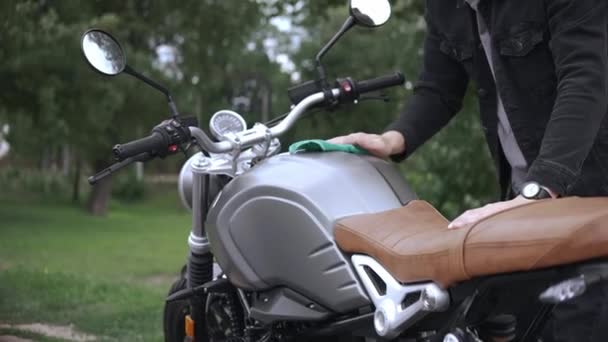 Wycieranie skórzanego motocykla z tkaniną na ulicy po umyciu go — Wideo stockowe