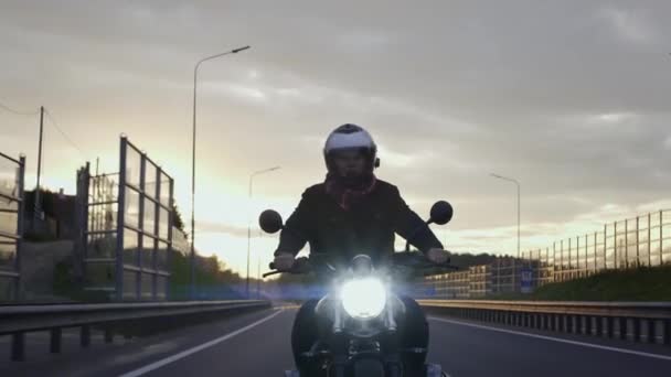 Férfi lovaglás zavaró motorkerékpár az autópályán a naplemente, elölnézet — Stock videók