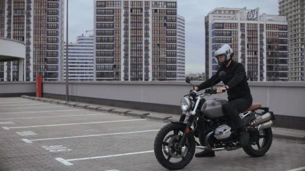 Man avvia una moto e guida in cima al parcheggio multilivello — Video Stock