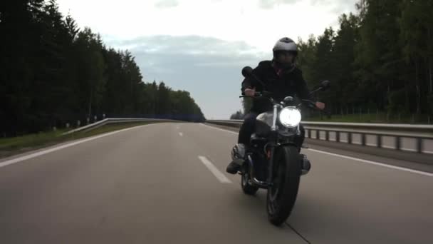 Man rider scrambler och svänger på motorvägen genom skogen, framifrån — Stockvideo