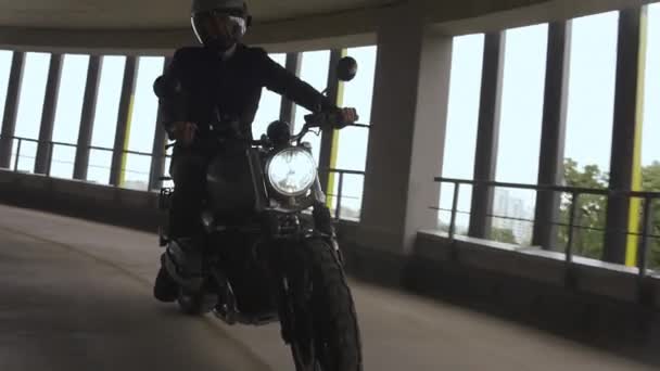 Man sta guidando una moto scrambler in cima al parcheggio multi-livello in città — Video Stock