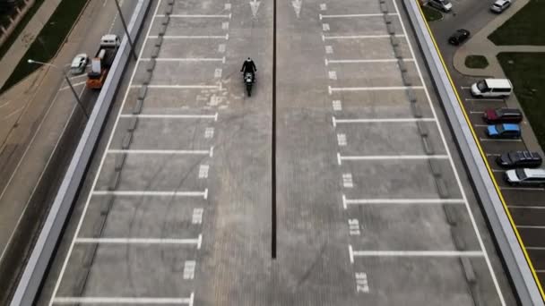 Homme moto sur le dessus du parking multi-levier en ville filmé avec drone — Video