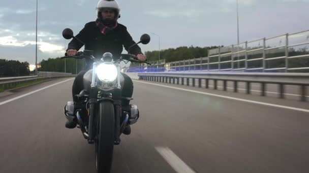 Uomo guida scrambler moto in autostrada con luci accese, vista frontale — Video Stock