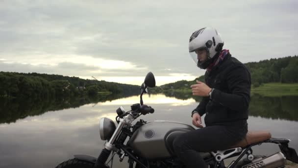 Man bär hjälm och starta motorcykel på en vacker höst landskap — Stockvideo