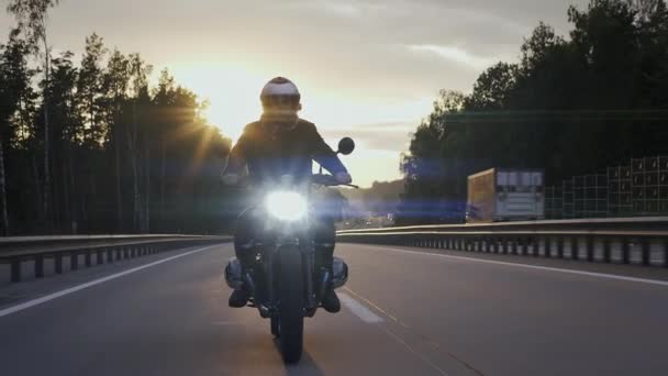 Homem andando de moto scrambler na estrada ao pôr do sol, vista frontal — Vídeo de Stock