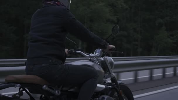 Uomo in sella scrambler moto sulla strada attraverso il buio forrest — Video Stock