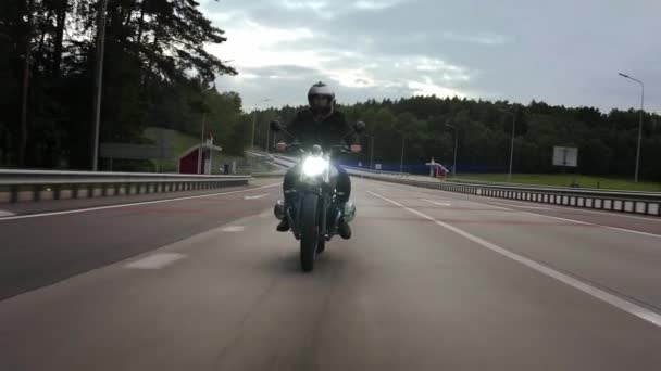 Man ridning scrambler motorcykel på motorvägen genom skogen, främre vy — Stockvideo