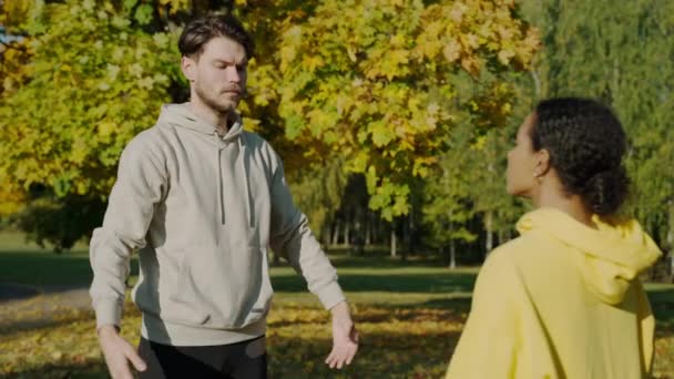 Mann und Frau bei Atemübungen im Park am Herbstmorgen — Stockvideo