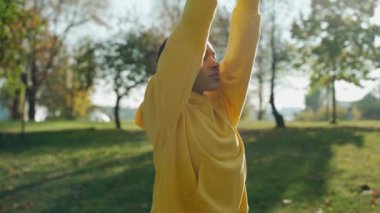 Sonbahar sabahı şehir parkında nefes egzersizi yapan bir kız.