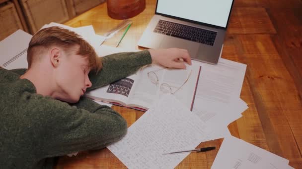 Man viel in slaap tijdens het doen van huiswerk aan de tafel, liggend op boeken, bovenaanzicht — Stockvideo
