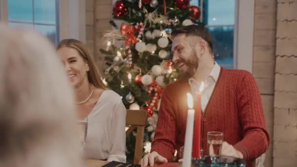 Hele familien taler og griner ved spisebordet juleaften – Stock-video