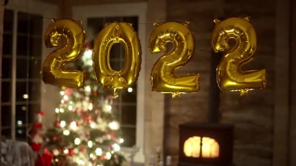 Globos de fiesta de año nuevo de oro del año 2022 frente al fondo festivo — Vídeo de stock