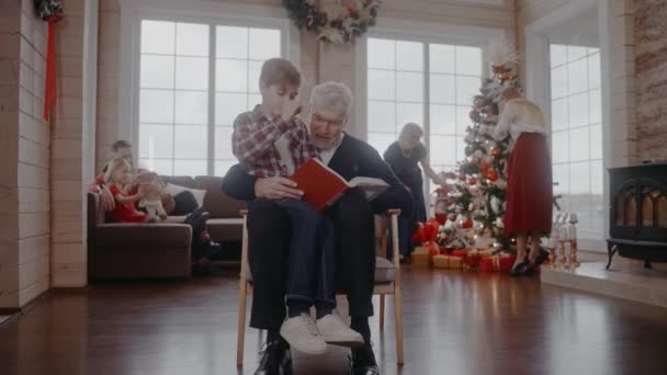 爷爷和孙子坐在椅子上看书庆祝圣诞节 — 图库视频影像
