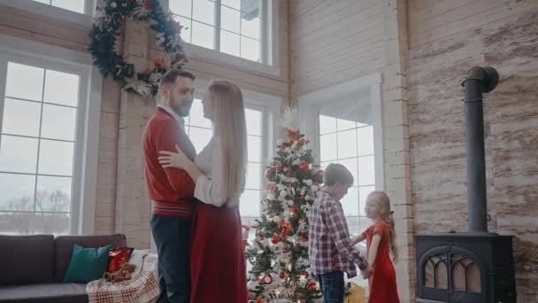 Szülők táncolnak együtt és gyerekek a háttérben is, karácsonyi hangulatban — Stock videók