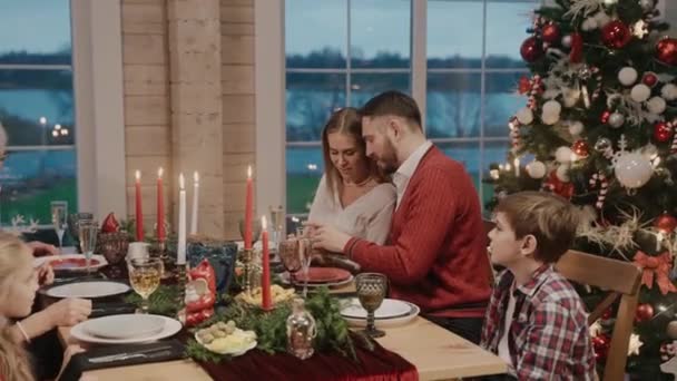 Bütün aile Noel arifesinde masada konuşuyor, adam oğlunun saçlarını okşuyor. — Stok video