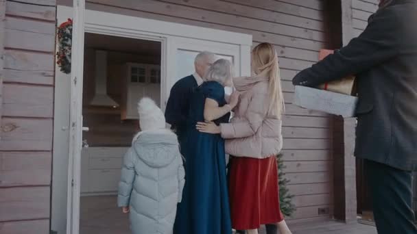 Familie mit Kindern kommt zur Weihnachtsfeier ins Haus der Großeltern — Stockvideo