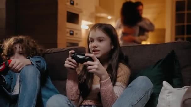 I bambini stanno giocando su console di gioco, i genitori ballano sullo sfondo — Video Stock
