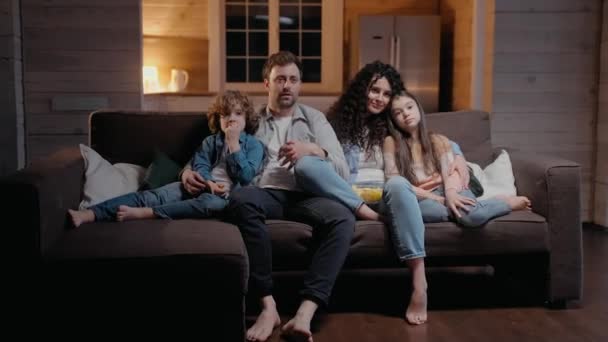 Aile evde birlikte film izliyor, patlamış mısır yiyor ve sarılıyor. — Stok video