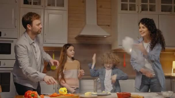 Сім'я готує вечерю вдома, збиваючи борошном, кидаючи його — стокове відео
