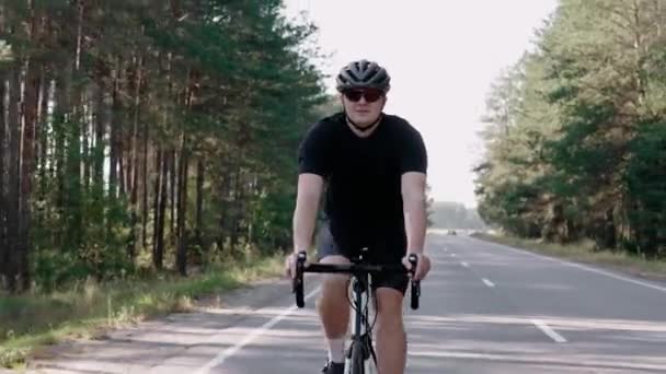 Передній знімок велосипедиста, який їде на шоломі в сонячному лісі — стокове відео