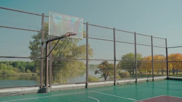 화창 한 가을에 공원의 빈 뜰에서 농구를 하는 모습 — 비디오