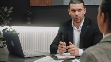 Erkek satıcı, modern gri ofis odasında kadınlara danışmanlık yapıyor.