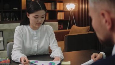 Akıllı kadın toplantıda oturan meslektaşlarıyla ya da ortaklarıyla konuşur.