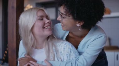 Kız arkadaşına arkadan sarılıyor ve alnından öpüyor.