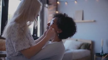 Lezbiyen genç çift öpüşüyor, sarılıyor ve gülümsüyor.