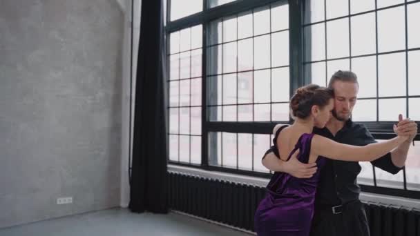 Volles Wachstum Aufnahme eines Paares, das Tango vor dem Hintergrund der großen Fenster tanzt — Stockvideo