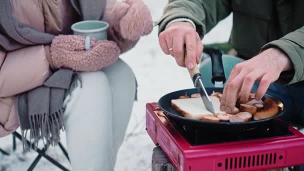 Пара готує обід в таборі на портативній плиті в лісі — стокове відео