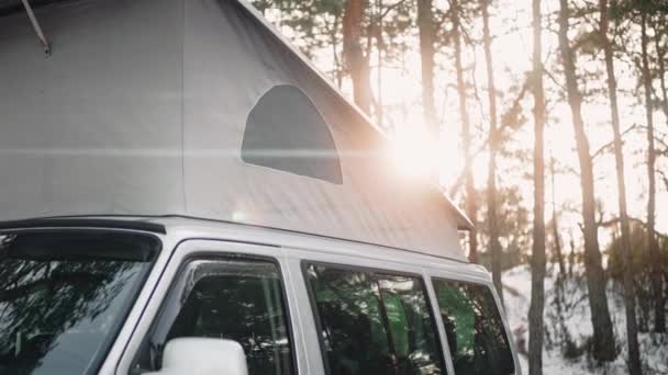 Близький знімок кемпінгового фургона з висунутим дахом на заході сонця в лісі взимку — стокове відео