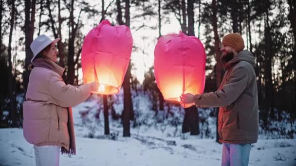 Pareja linterna de cielo claro y abrazo en el bosque en invierno, celebrando San Valentín — Vídeos de Stock
