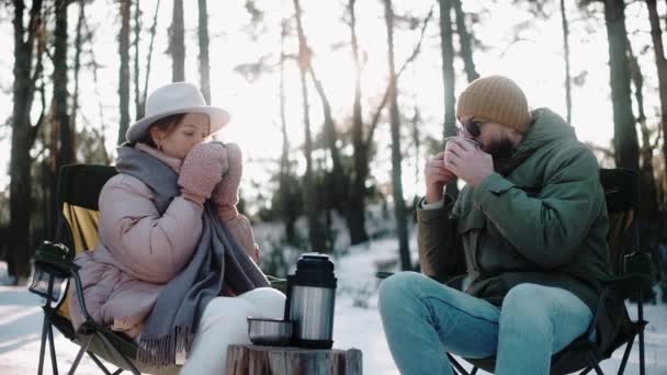 Ζευγάρι πίνοντας ζεστό τσάι στο δάσος το χειμώνα, απολαμβάνοντας τη ζωή στρατόπεδο — Αρχείο Βίντεο