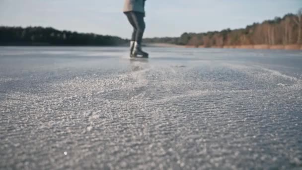 Primer plano de un hombre entrenando hockey parada en un lago congelado en un día soleado solo — Vídeo de stock