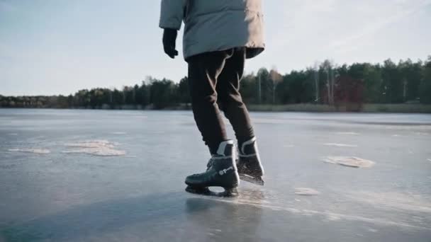 Člověk cvičí bruslení na čistém zamrzlém jezeře za slunečného dne, takže led jiskří — Stock video