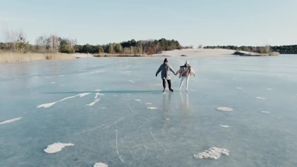 Luftaufnahme eines Paares beim Schlittschuhlaufen auf einem blau gefrorenen See in wunderschöner sonniger Landschaft — Stockvideo