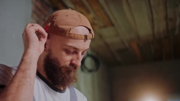 Man bouwer neemt een potlood van achter zijn oor en schrijft metingen — Stockvideo