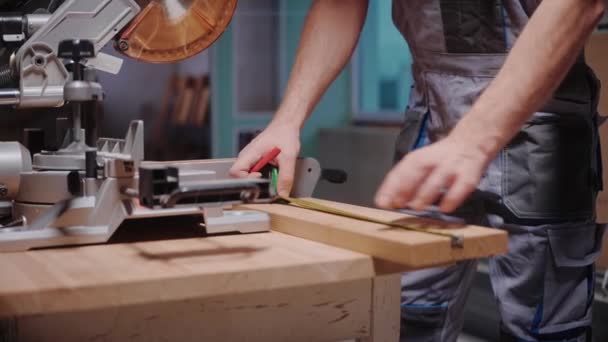 Stavitel měří dřevěnou desku na řezání na stole kruhové pily — Stock video