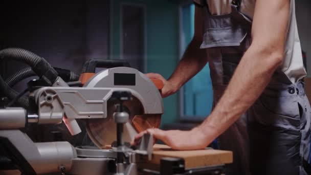 Stavitel krájí dřevěnou desku na stole kruhové pily ve stavebním studiu — Stock video