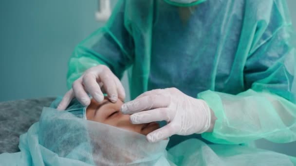 Shot close-up dokter bedah melakukan rhinoplasty dalam gaun pelindung hijau — Stok Video