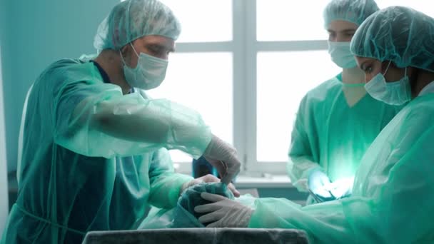 Trei chirurgi care efectuează rinoplastie în rochii verzi de protecție — Videoclip de stoc