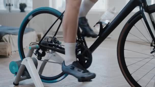 Close shot van een fietser benen training op een hometrainer thuis — Stockvideo