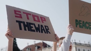 Protestocular işaretlerini sallayıp ilahi söylüyorlar. Gençler Ukrayna 'daki savaşı durdurmak için işaretler ve ilahiler yazıyor. Politik gösteri. Alıntılı posterler savaşı durdurur. Yüksek kalite 4k görüntü