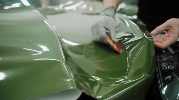 Διαδικασία Του Βινυλίου Τυλίγοντας Μια Κουκούλα Αυτοκινήτου Σκούρο Πράσινο Χρώμα — Αρχείο Βίντεο