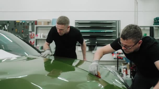 Dos Hombres Están Envolviendo Coche Vinilo Color Verde Oscuro Usando — Vídeos de Stock