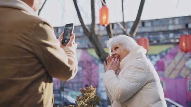 Starsza Para Robi Zdjęcia Uśmiechając Się Smartfonie Nowoczesnej Ulicy Starsza — Wideo stockowe