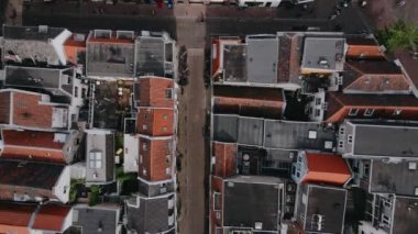 Eski Avrupa şehrindeki kırmızı tuğlalı evlerin insansız hava aracı görüntüsü. Hollanda sokakları ve havadan çekilen tuğlalı evler. Şehir sokaklarında bisikletle gezen insanlar havadan vurulmuş. Yüksek kalite 4k görüntü